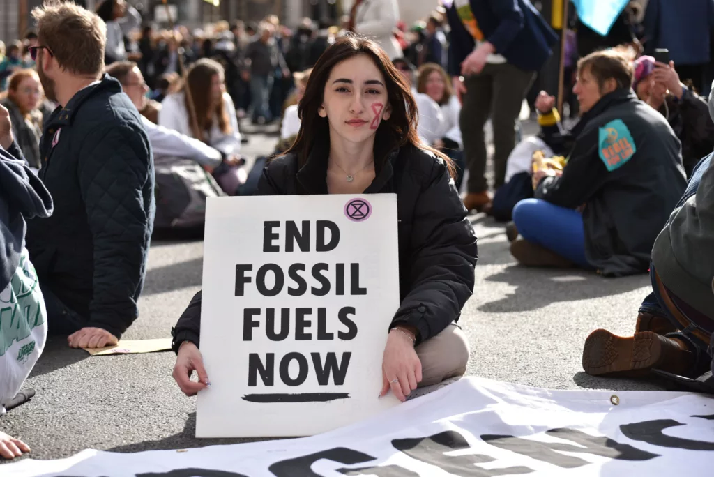 A young activist holds a sign calling for the end of fossil fuel use during a peaceful protest.
