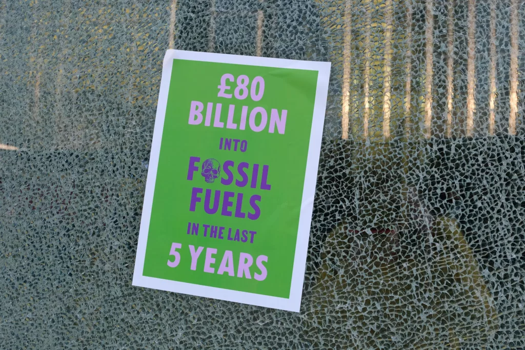 Bold environmental statement poster highlighting £80 billion investment in fossil fuels over the past 5 years, displayed against a textured background.