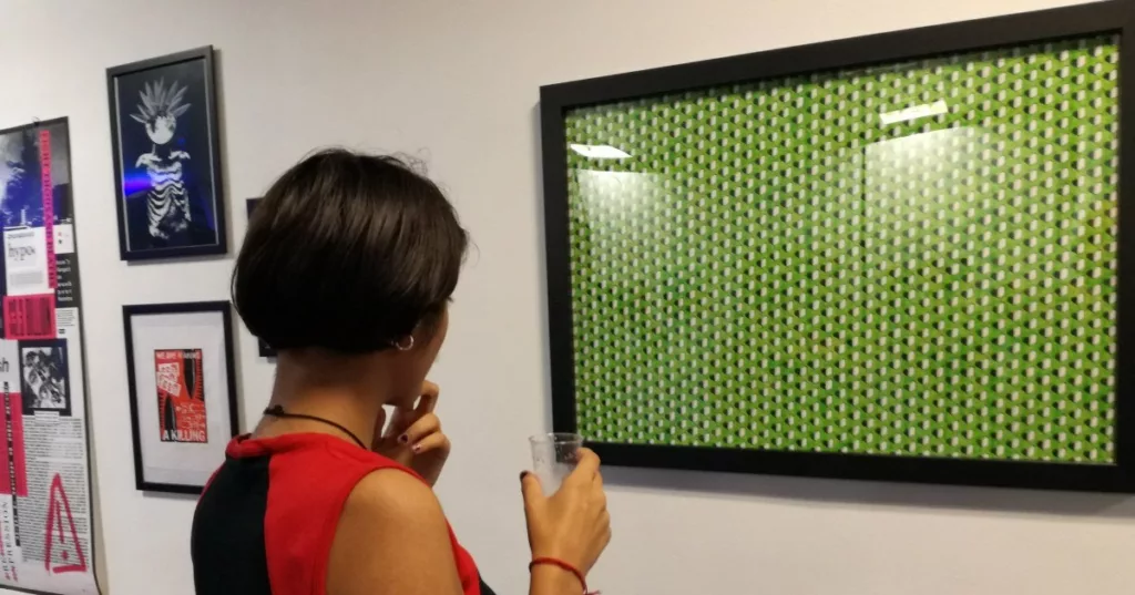 A person observes a print on a wall of grave stones at Art the Arms Fair