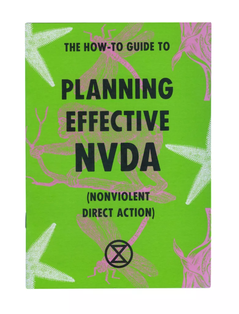 A book cover titled "the how-to guide to planning effective nvda (nonviolent direct action)" with a bright green background, adorned with illustrations of foliages and insects in pink and white, featuring bold typography and an emblem of a circled a, often associated with anarchy, at the bottom center.