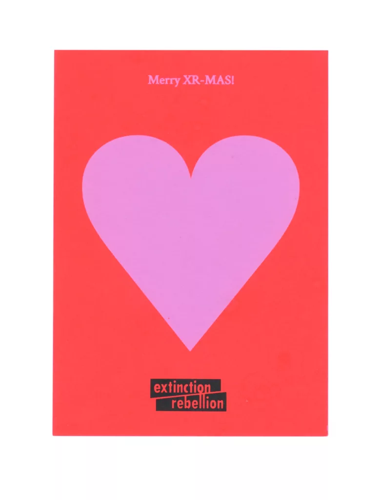 Christmas greeting card with a bold pink heart on a red background, featuring the message "merry xr-mas!" and the extinction rebellion logo at the bottom.
